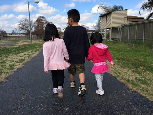 Sid’s three children walking together along a park path